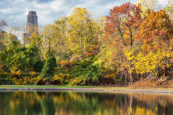 The Cathedral of Learning and fall colors reflect in Panther Hollow Lake in the fall