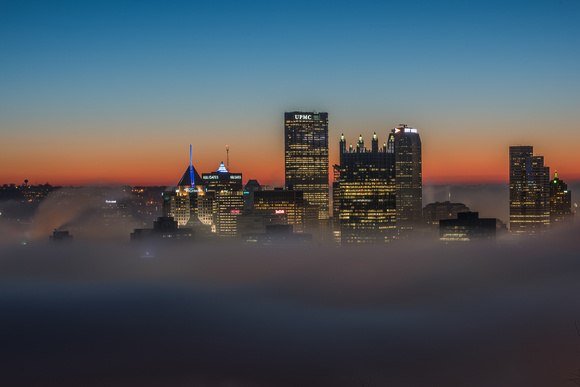 The Pittsburgh skyline looks like it is floating amongst the clouds on a foggy morning