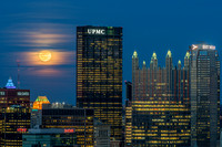 The rising full moon sits behind the clouds in Pittsburgh