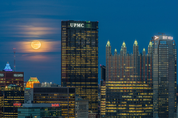 The rising full moon sits behind the clouds in Pittsburgh