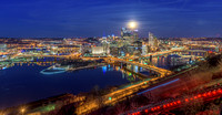 Light streaks from the incline and a full moon over Pittsburgh