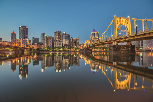Pittsburgh and Roberto Clemente Bridge reflect in the Allegheny at dusk