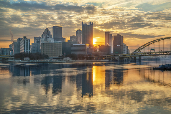 Pittsburgh lit up at dawn by the rising sun