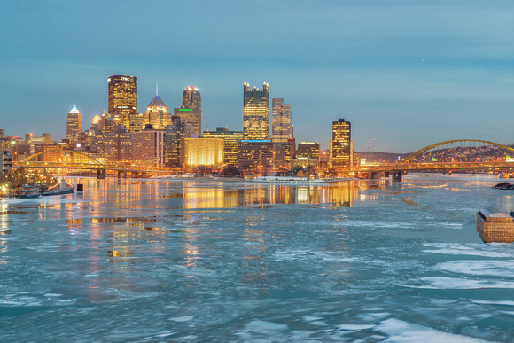 Pittsbrgh at the blue hour from the West End Bridge behind the ice Ohio River