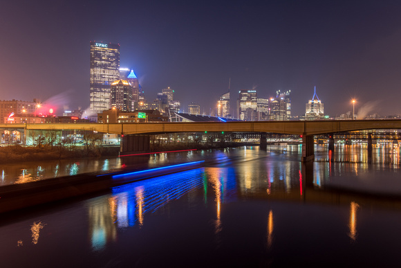 A barge streaks up the Allegheny River in Pittsburgh