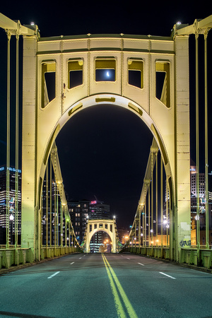 The Roberto Clemente Bridge frames the moon on an early morning in Pittsburgh