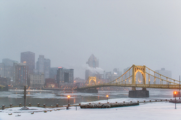 Roberto Clemente Bridge lit up in the snow along the North Shore of Pittsburgh