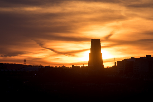 The Cathedral of Learning is silhouetted against the rising sun
