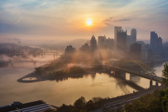 The sun breaks through downtown Pittsburgh and the early morning fog