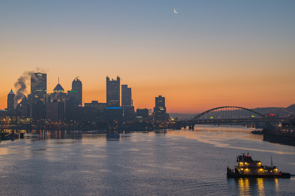A barge on the river under the moon in Pittsburgh