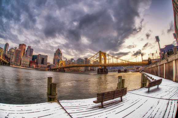 A lonely bench in the snow and the Pittsburgh skyline HDR