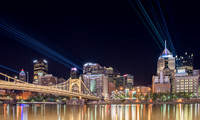 Lasers shine across the river and display the Bat symbole on downtown Pittsburgh