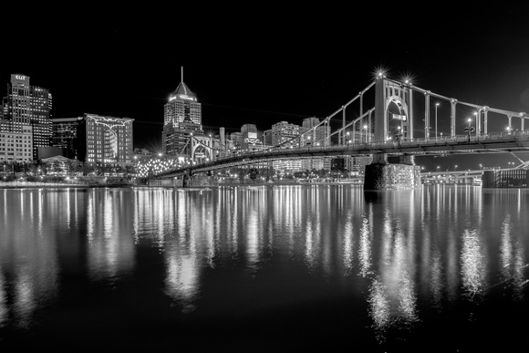 Black and white view of the Clemente Bridge and Bat Signal in Pittsburgh