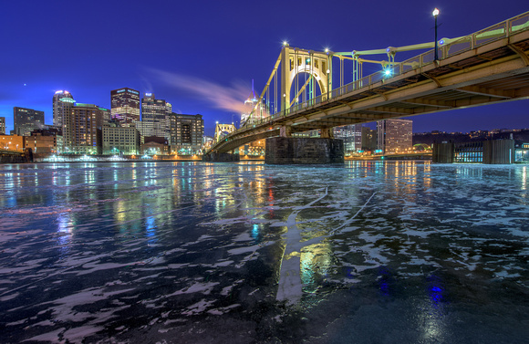 The Clemente Bridge in Pittsburgh reflects in the icy Allegheny