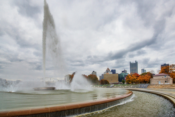 The fountain rises beside the Pittsburgh skyline in the fall