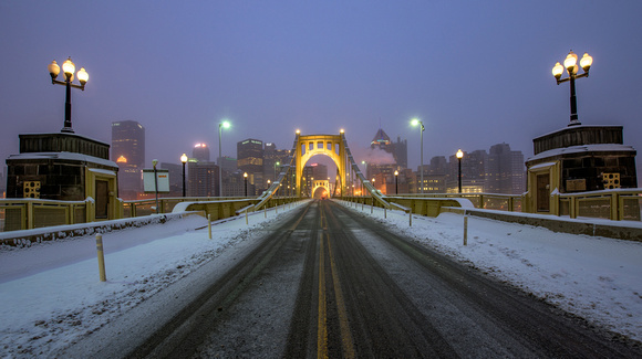 The Clemente Bridge glows in the early morning snow in Pittsburgh