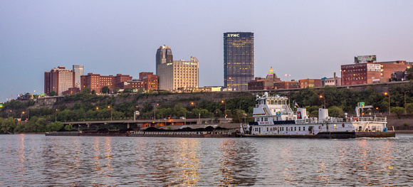 A barge passes in front of Pittsburgh on the Mon