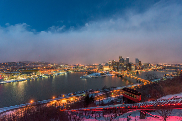An incline climbs Mt. Washington during a snow squall at dusk in Pittsburgh