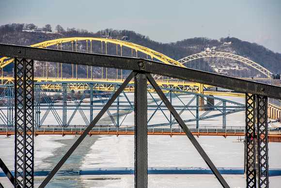 Bridges in Pittsburgh over snowy rivers