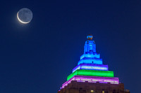 A sliver of moon by the colorful Gulf Tower in PIttsburgh