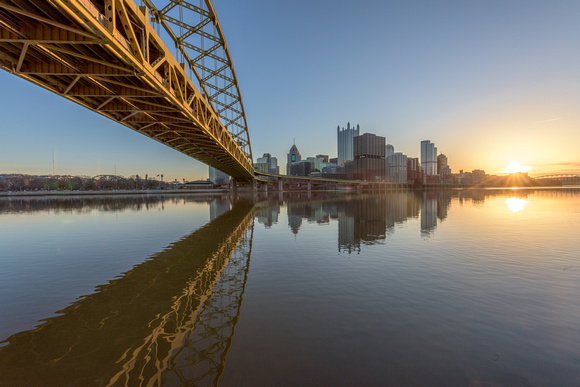 The rising sun reflects in the still waters of the Mon River on a beautiful Pittsburgh morning