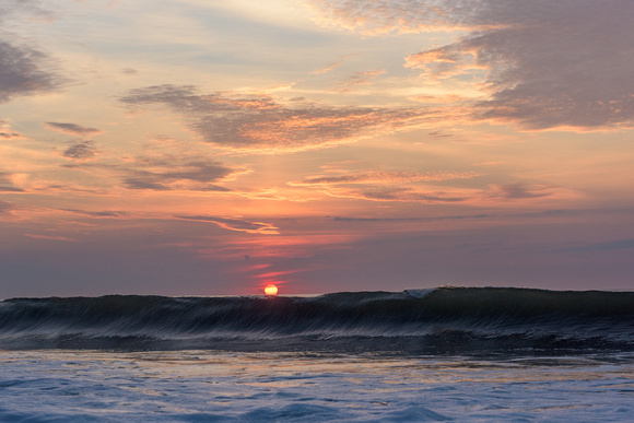 The sun sits on top of a wave in Ocean City, MD