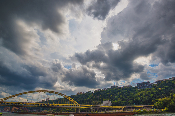 The sun behind clouds over the Ft. Pitt Bridge
