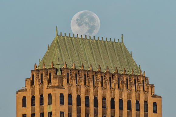 The full moon sits atop the Koppers Building in Pittsburgh