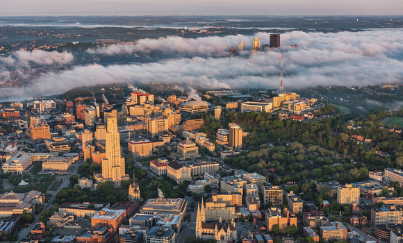 Sunlight shines on Pitt's campus as Pittsburgh sits in the fog at dawn