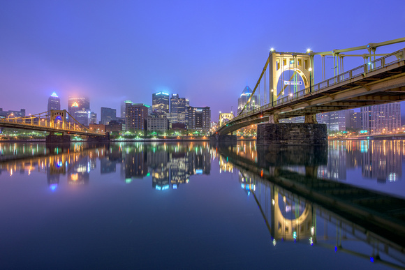The Clemente Bridge reflects in the Allegheny on a foggy Pittsburgh morning