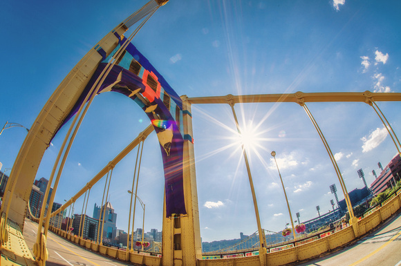 The sun shines through a yarn bombed Andy Warhol Bridge in Pittsburgh