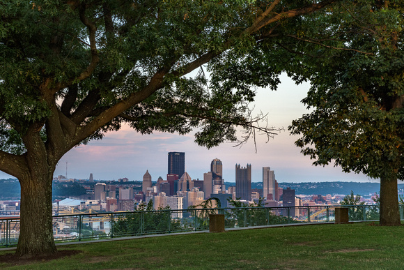 Trees frame the West End Overlook at dusk in Pittsburgh