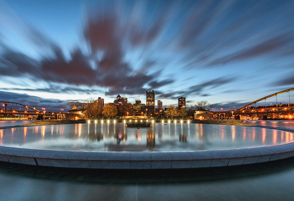 Clouds rush over Pittsburgh and the fountain basin at Point State Park