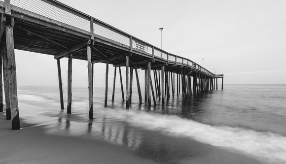 Water rushes under a pier at Ocean City, MD