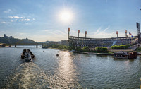 Sunflare over PNC Park and a barge on the river in Pittsburgh