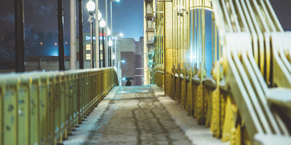 A man walks over the Clemente Bridge on a snowy morning in Pittsburgh