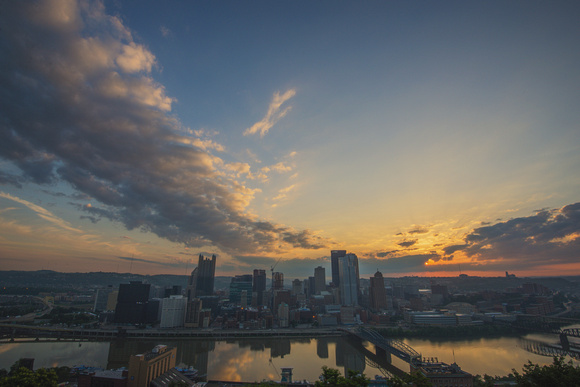 A dark Pittsburgh under a colorful sky