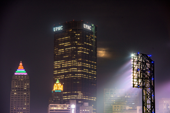 The full moon behind clouds and the Steel Building in Pittsburgh