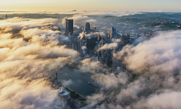 The sun illuminates the fog over Pittsburgh at dawn