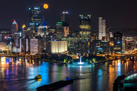 A beautiful moon rises over Pittsburgh as the city reflects in the Ohio River