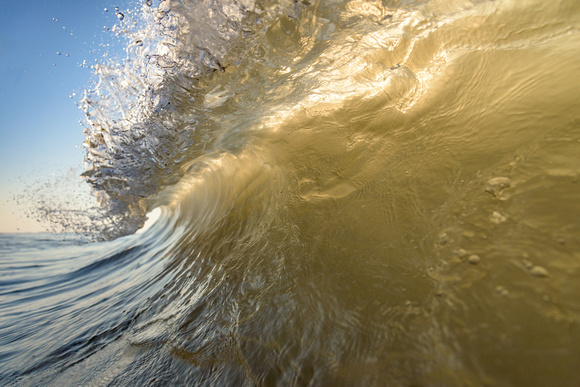 A wave crashes on the shore of Ocean City, MD at dawn