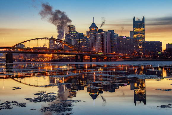 Pittsburgh reflects between the ice of the Allegheny River