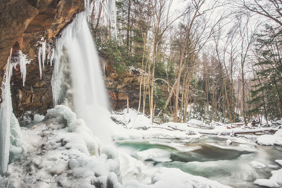 Behind a snow and ice covered Cucumber Falls at Ohiopyle State Park in the winter