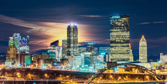 The full moon glows behind the Pittsburgh skyline