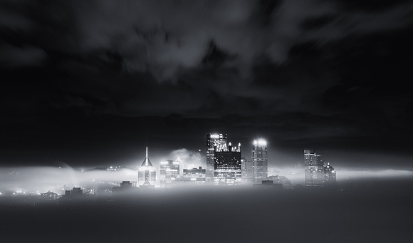 A black and white view of a fog covered city