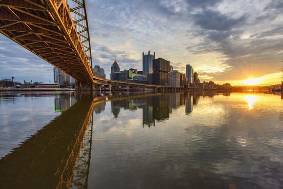 A beautiful sunrise reflects in the calm waters of the Monongahela River
