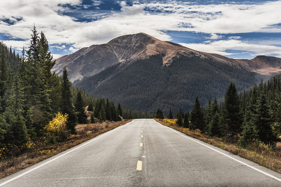An empty road leads through the mountains in Colorado