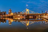A panorama of the Clemente Bridge and the moon reflecting in the water