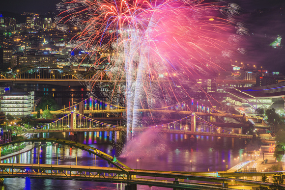 Fireworks light up the Pittsburgh night in front of the colorful Rachel Carson Bridge