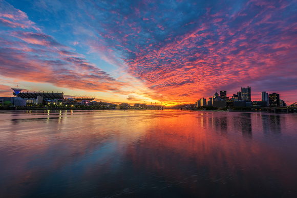 A colorful sunrise reflects in the rivers of Pittsburgh